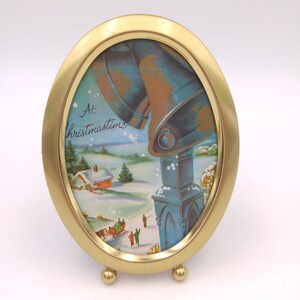 Vintage ingelijste kerstkaart-ovale frame klokken en kleine stad scène
