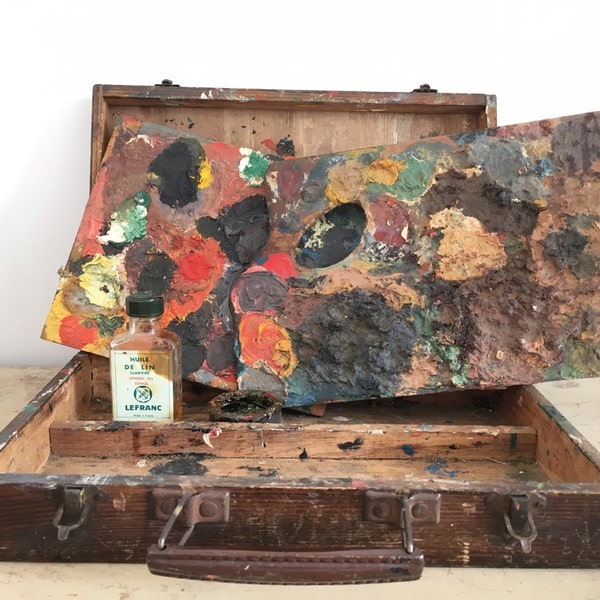 Caja de madera antigua y sus paletas de pintura.