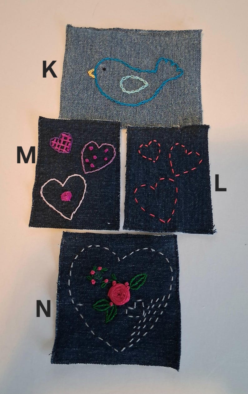 Puede incluir: Cuatro parches de mezclilla con dise&ntilde;os bordados. Uno presenta un p&aacute;jaro azul, otro tiene tres corazones y un tercero un coraz&oacute;n con una rosa y hojas. El cuarto parche tiene tres corazones.