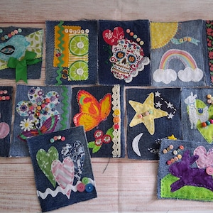 Peut inclure: Une collection de onze patchs rectangulaires en jean avec divers motifs appliqués, notamment un oiseau, des tranches de citron vert, une tête de mort, un arc-en-ciel, des cerises, une fleur, un papillon, une étoile, un lama, des cœurs et un lapin, ornés de boutons.