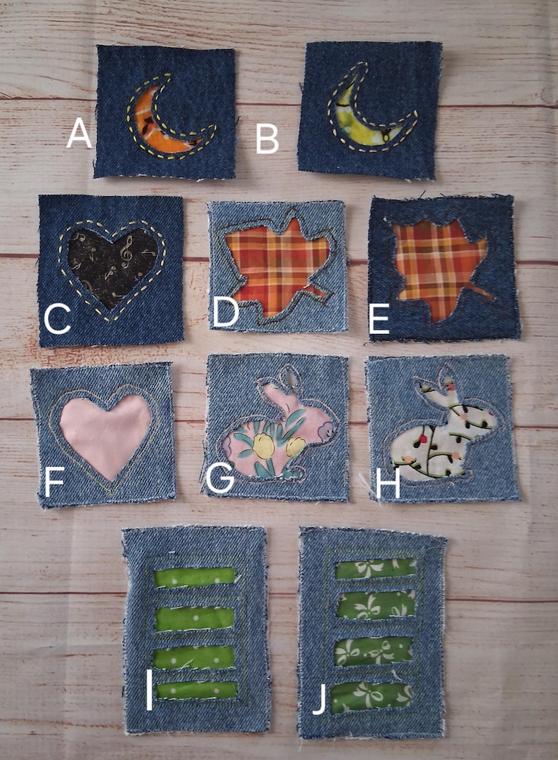 May include: A collection of ten denim patches with various appliqued designs. The patches feature a crescent moon, heart, leaf, and rabbit motifs. Some patches have green or patterned fabric inserts. The patches are square and have a raw edge.