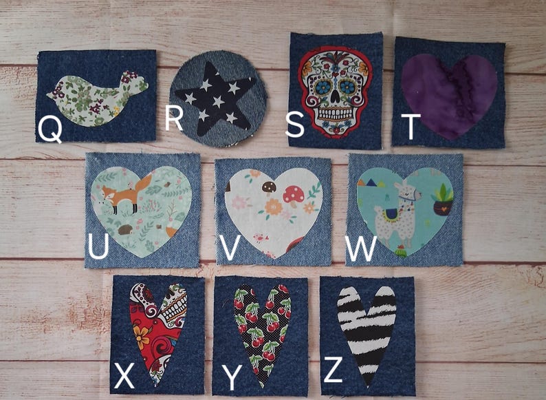 May include: A collection of denim patches with various fabric appliqu&eacute;s. Designs include a bird, star, sugar skull, purple heart, fox, floral heart, llama, and hearts with skull, cherry, and zebra patterns. Each patch is a unique design.