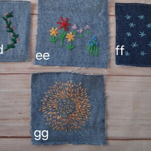 May include: Four denim fabric squares with embroidered designs. One square features a green vine, another has colorful flowers, a third has blue star-like shapes, and the last has an orange spiral design. The squares are labeled with the letters dd, ee, ff, and gg.