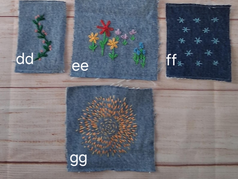 May include: Four denim fabric squares with embroidered designs. One square features a green vine, another has colorful flowers, a third has blue star-like shapes, and the last has an orange spiral design. The squares are labeled with the letters dd, ee, ff, and gg.