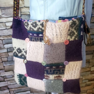 May include: A patchwork shoulder bag made from different knitted fabrics in shades of pink, purple, gray, and brown. The bag has a variety of buttons in different colors and patterns.