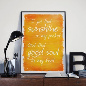 Puede incluir: Una impresión enmarcada con un fondo de acuarela amarillo y naranja. El texto en la impresión dice "I got that sunshine in my pocket Got that good soul in my feet".