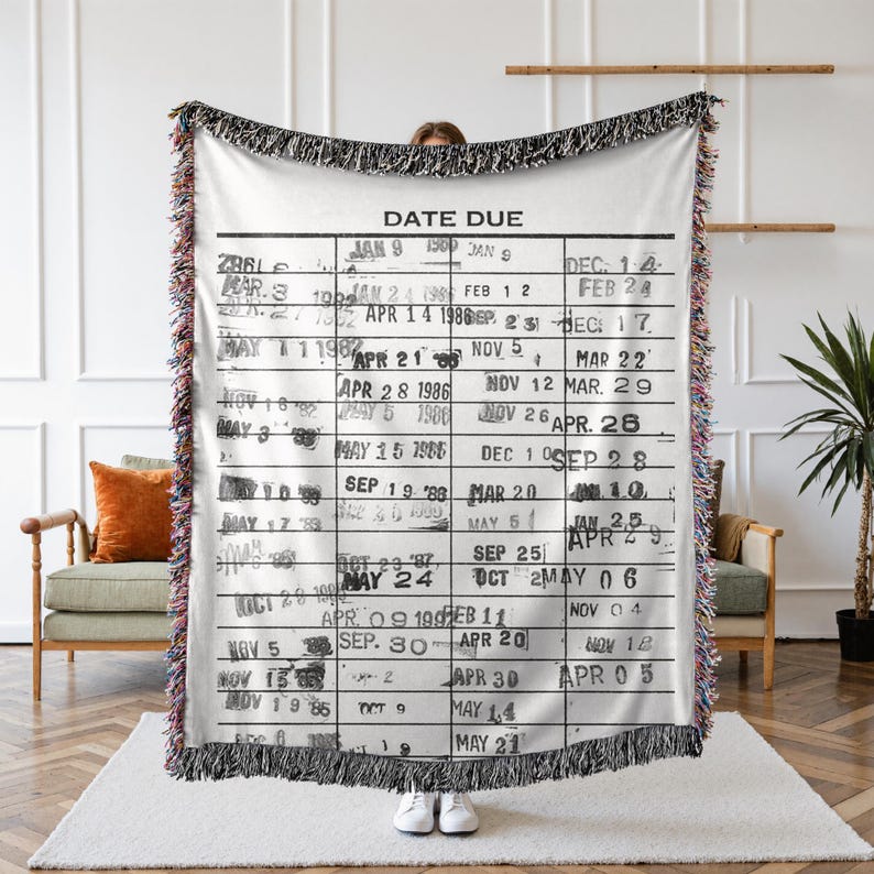May include: A white woven tapestry with a black and white design of a library card with the text "DATE DUE" and a grid of dates.