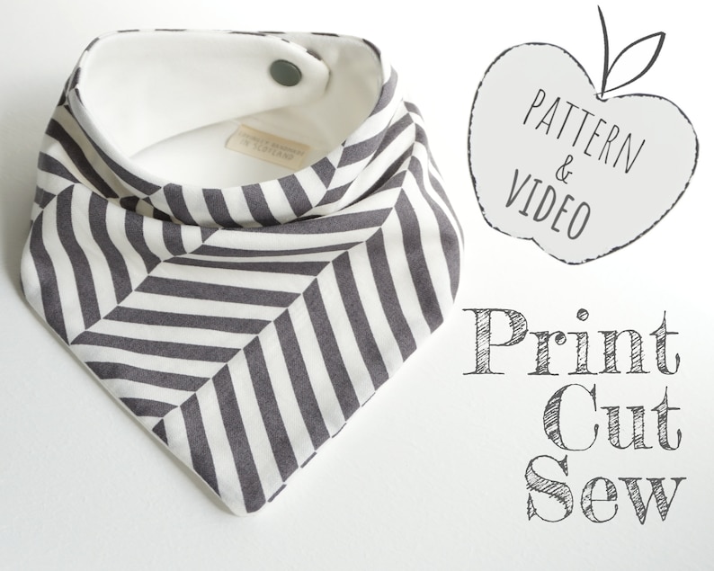 May include: A black and white striped fabric baby bib with a white fleece lining and a snap closure. The bib is shaped like a triangle with rounded corners. The text "Print Cut Sew" is written in a handwritten font below the bib.