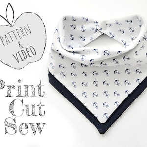 May include: A white bandana with a navy blue anchor print and a navy blue border. The bandana is folded in half and has a pattern of small anchors repeated across the fabric. The text "PATTERN & VIDEO" is written on a gray apple shape and the text "Print Cut Sew" is written in a stylized font below the apple.