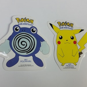 May include: Two Pokemon stickers, one featuring Pikachu, a yellow electric mouse Pokemon with red cheeks, and the other featuring Poliwhirl, a blue water Pokemon with a spiral on its belly. Both stickers have the Pokemon logo and the text "Gotta catch 'em all!"