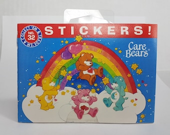 May include: A sticker pack featuring Care Bears characters. The pack has a blue background with a rainbow and stars. The characters are Cheer Bear, Funshine Bear, Good Luck Bear, and Wish Bear. The text on the pack reads "Collect 'Em & Trade" and "Care Bears".