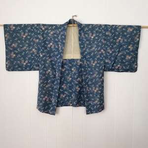 Könnte beinhalten: Ein blauer und weißer japanischer Kimono mit floralem Muster und cremefarbener Futter.