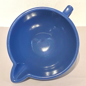 May include: A blue ceramic mixing bowl with a spout and a handle. The bowl is empty and has a glossy finish.