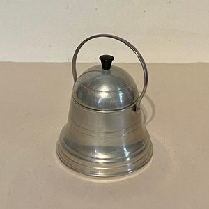 May include: A silver aluminum bell-shaped sugar dispenser with a black knob on the lid and a handle.