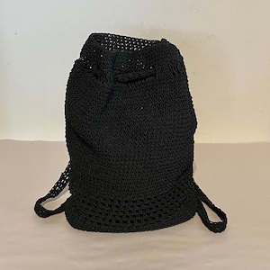 Könnte beinhalten: Schwarzer gehäkelter Rucksack mit Kordelzug und verstellbaren Trägern.
