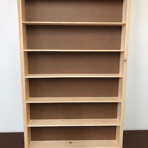 May include: A wooden shelf unit with six shelves. The shelves are made of natural wood and have a light brown finish. The unit is empty and ready to be filled with items.