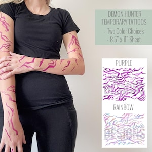 May include: A person with purple temporary tattoos on their arms and hands. The tattoos have a jagged, abstract design. The image also shows two color options: purple and rainbow. The text reads "DEMON HUNTER TEMPORARY TATTOOS - Two Color Choices - 8.5" x 11" Sheet."