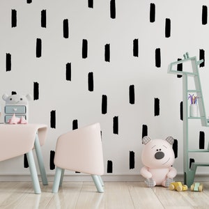 May include: A light blue wooden giraffe-shaped bookshelf with shelves and a storage basket. The bookshelf is decorated with black brushstroke patterns. There is a pink teddy bear sitting on the floor in front of the bookshelf. There is a pink table and chair set with a wooden toy box and a white lamp.