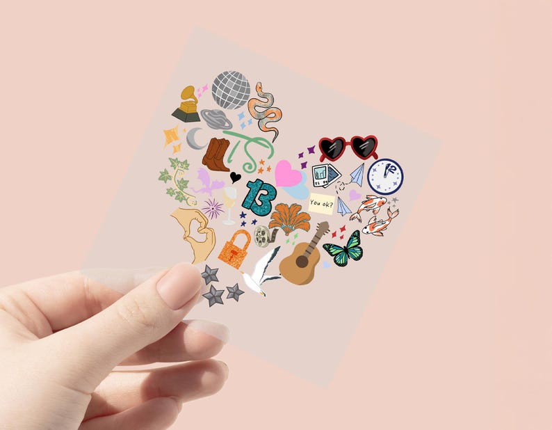 May include: A heart-shaped sticker with various colorful illustrations, including a disco ball, snake, boots, and guitar. Other elements include a lock, butterfly, and the number 13. The sticker is held by a hand against a pink background.