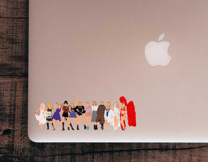 May include: A sticker featuring a group of stylized figures in various outfits. The figures are depicted in a range of colors, including white, black, blue, and red. The sticker is placed on a silver laptop.