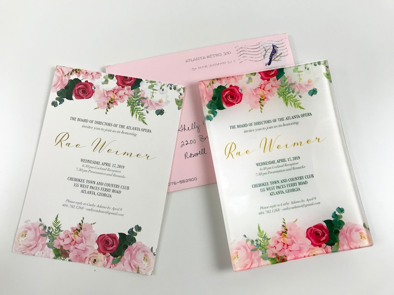May include: A white invitation with pink and red floral border. The text reads "The Board of Directors of the Atlanta Opera invites you to join us in honoring Rae Weimer. Wednesday, April 17, 2019. 6:30 pm Cocktail Reception. 7:00 pm Presentation and Remarks. Cherokee Town and Country Club, 155 West Paces Ferry Road, Atlanta, Georgia."
