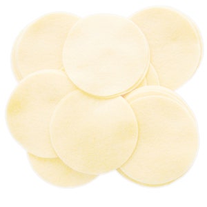 May include: A stack of round, off-white, paper-like discs. The discs are arranged in a random pattern, with some overlapping.