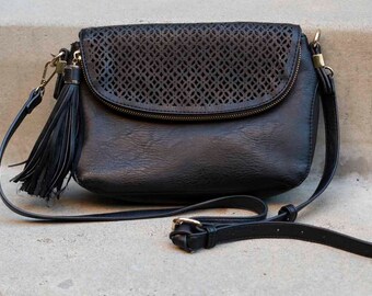 Bolso bohemio negro con solapa cortada con láser y detalle de borla: un estilo chic y desenfadado para el día o la noche.
