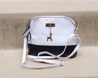 Bolso bicolor blanco y negro con un adorno de ciervo: sencillo, elegante y versátil.
