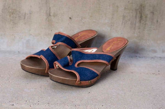 Wooden-soled sandals with denim straps for a rustic-meets-modern flair—perfect for laid-back style.