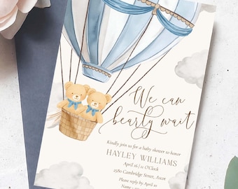 Könnte beinhalten: Babyparty-Einladung mit einem blau-weißen Heißluftballon-Design und zwei Teddybären in einem Korb. Der Text lautet "We can bearly wait" mit Veranstaltungsdetails. Die Einladung ist von Blumen und Grün umgeben.
