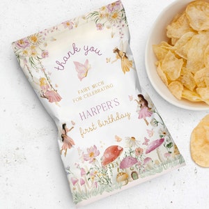 May include: A white chip bag with a whimsical fairy theme. It features a pink and gold border with flowers, mushrooms, and fairies. The text reads "Thank you Fairy much for celebrating Harper's first birthday."