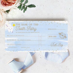 May include: A blue and white tooth fairy check with gold stars and the text "The Bank of the Tooth Fairy" and "123 Twinklewing Hollow, Dreamland TF01". The check has a space for the recipient's name, the amount in words, and the amount in numbers. The check is signed "Tooth Fairy" and the amount is $10.00.