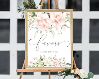 May include: A white sign with a gold frame and floral design. The sign says "favors" in cursive script and "Please take one." in black text.