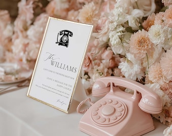 May include: A pink vintage telephone and a framed sign with gold trim. The sign has a black telephone graphic and the text "The Williams" and "Can't come to the phone right now". The background features soft pink flowers.