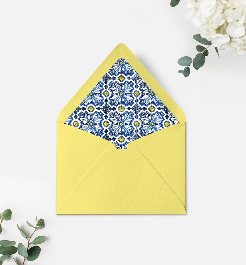 May include: A yellow envelope with a blue and white patterned liner. The pattern features a repeating design of stylised flowers and geometric shapes.