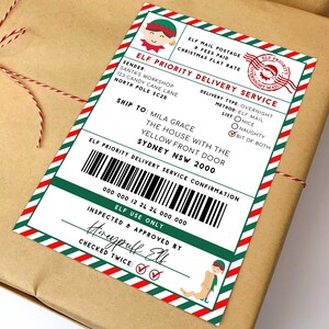 Peut inclure: Un colis de Noël avec une étiquette de service de livraison prioritaire des elfes. L'étiquette présente une bordure verte et rouge, un graphisme d'elfe et du texte, y compris les options "Méchant" et "Gentil". Le colis est enveloppé dans du papier brun et ficelé avec de la ficelle.