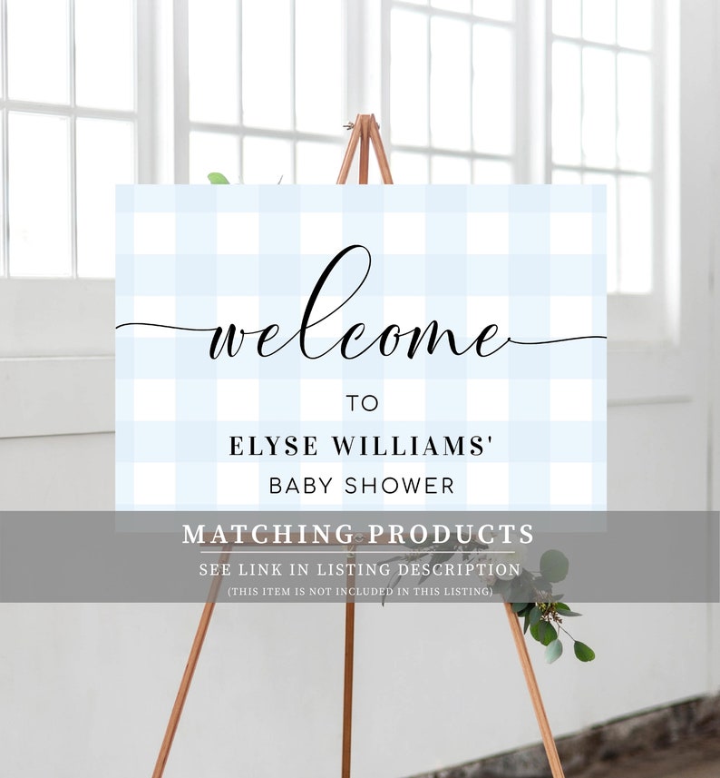 Może przedstawiać: Witamy znak na baby shower na drewnianym sztaludze. Znak ma jasnoniebieskie i białe tło w kratkę vichy ze słowem "welcome" w eleganckim czarnym skrypcie. Znak brzmi "To Elyse Williams' Baby Shower".