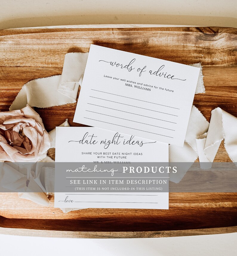 Pu&ograve; includere: Due carte bianche con testo nero. La carta superiore dice "words of advice" e ha delle righe per scrivere. La carta inferiore dice "date night ideas" e ha una riga per scrivere. Le carte sono su una superficie di legno con un fiore rosa e un nastro bianco.