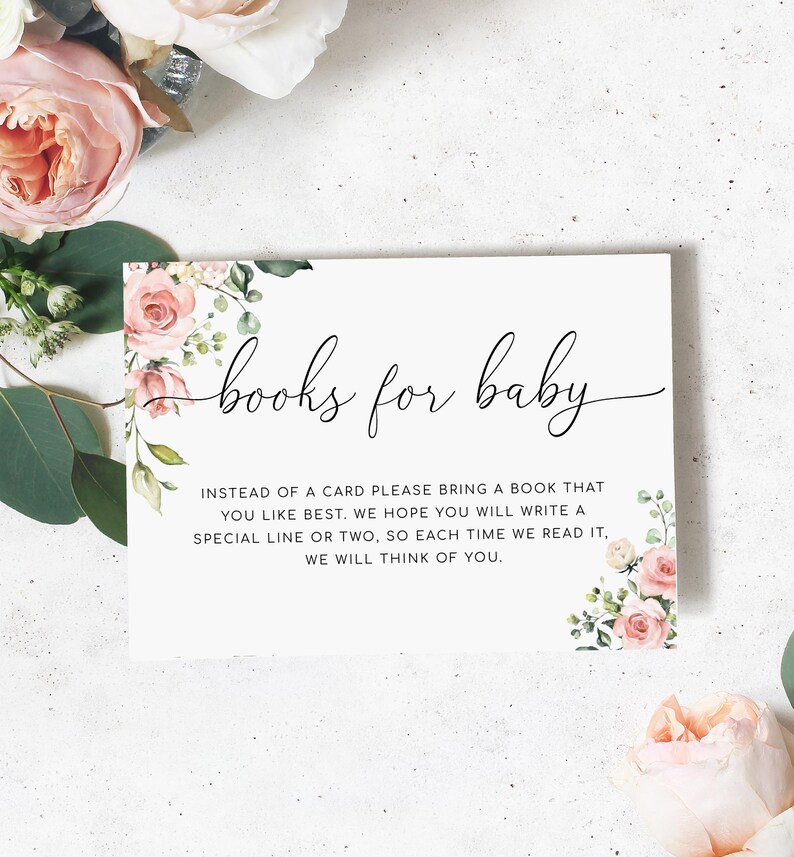 以下が含まれることがあります： ピンクの花柄のイラストが描かれた白いカードに「books for baby」の文字が書かれています。カードには、カードの代わりに本を持参し、本に特別な行を1行か2行書いてくださいと書いてあります。