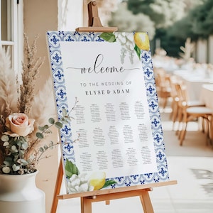 Peut inclure: Un plan de table de mariage blanc avec une bordure de motif de carrelage bleu et blanc. Le tableau porte le texte "Bienvenue au mariage d'Elyse & Adam" en haut. Le tableau liste les noms des invités par numéro de table.