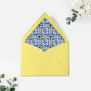May include: A yellow envelope with a blue and white patterned liner. The pattern features a repeating design of stylised flowers and geometric shapes.