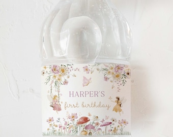 Puede incluir: Etiqueta de botella de agua con un diseño floral y hadas. La etiqueta dice "Harper's first birthday".