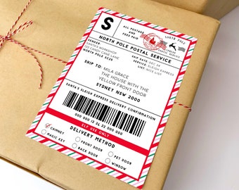 Może przedstawiać: Brązowy pakunek przewiązany czerwono-białym sznurkiem. Na pakunku znajduje się prostokątna naklejka z napisem "North Pole Postal Service". Naklejka zawiera kod kreskowy i dane adresowe.