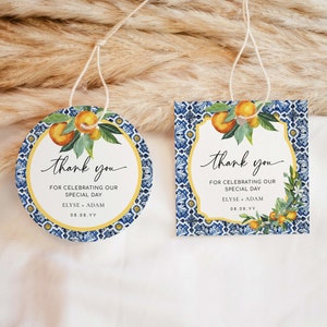May include: Two round thank you tags with blue and white patterned backgrounds and a yellow border. The tags feature a watercolour illustration of lemons and leaves. The text on the tags reads "thank you for celebrating our special day Elyse + Adam 08.08.YY".