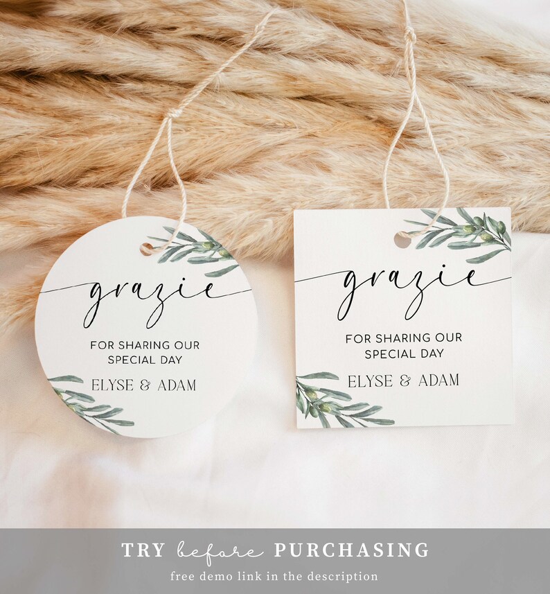 May include: Two round, white favour tags with a green olive branch design. The text on the tags reads "grazie" and "For sharing our special day Elyse & Adam".