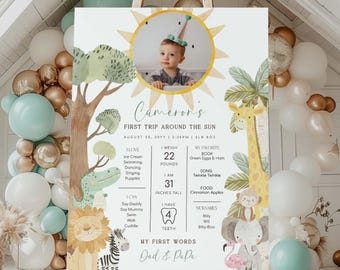 May include: A colourful first birthday milestone poster with a jungle theme. The poster features a photo of a baby boy in a sun with a giraffe, zebra, lion, monkey, and elephant. The poster includes the baby's name, age, weight, height, favourite book, song, food, and first words.