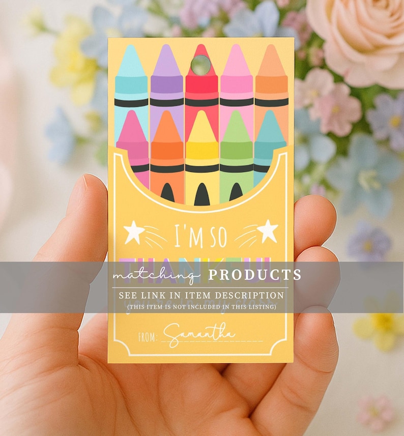 May include: A yellow card featuring a crayon box design with colorful crayons. The card has the text "I'M SO" and "matching PRODUCTS". The card is held in a hand, with a floral background.
