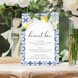 Puede incluir: Un cartel blanco con diseños florales azules y amarillos y el texto "PLEASE ENJOY A TREAT dessert bar" enumera las opciones de postre: cupcakes, donuts y otras delicias.