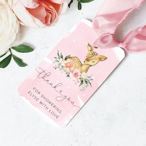 May include: Pink thank you tag with white polka dots and a watercolour background. The tag features a cute fawn with a floral wreath around its neck. The text on the tag reads "Thank you for showering Elyse with love."