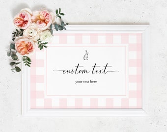May include: White frame with a pink and white gingham pattern inside. The frame has a white mat and a small black and white illustration of a rabbit. The text "custom text" is written in black cursive script with the words "your text here" below it.